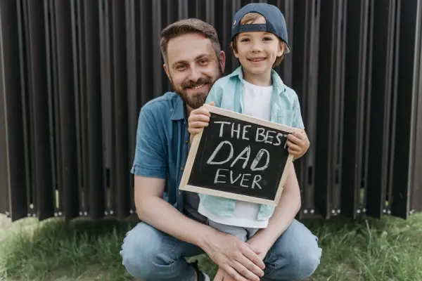 Isä ja poika pitelevät Best Dad Ever -kylttiä